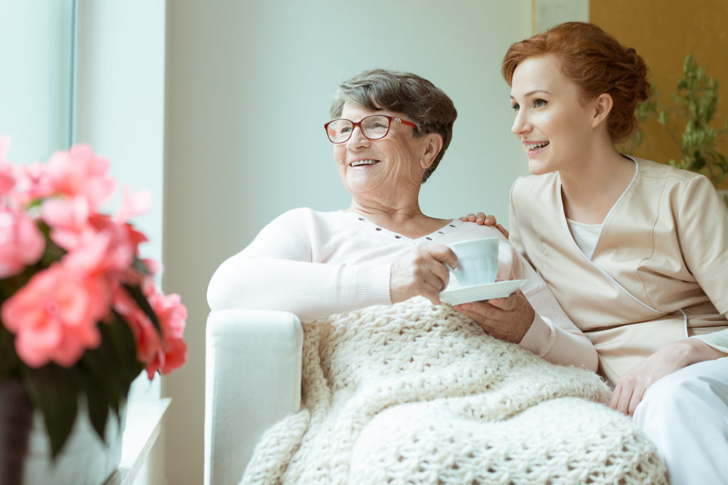 Seniorin mit junger Frau und Kaffeetasse